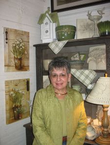 Ginny Paul standing with some of the displays at the Country Store, 2009.